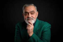 Portret profesional senior în costum verde, fotografie de studio fundal negru, imagine business rafinată