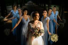 Mireasă înconjurată de domnișoarele de onoare, rochii bleu și buchete delicate, fotografie de nuntă realizată în București