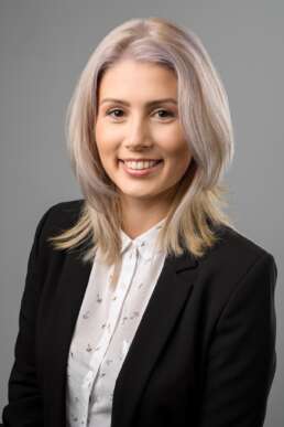 Portret business profesional femeie, fundal gri, ținută elegantă business, fotografie corporate pentru profil LinkedIn sau website companie